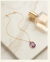 Collar de acero con baño de oro, compuesto por una cadena fina y un dije hexagonal de piedra amatista natural con una circonia rectangular engastada en el centro.