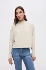 Remera de manga larga con cuello polera, confeccionada en tela texturizada con calce relajado.