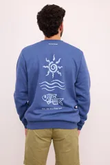 Sudadera azul de cuello redondo, manga larga y puños y dobladillo acanalados. Presenta un estampado de sol en color blanco en el lado izquierdo del pecho.