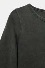 Camiseta de algodón color terracota con efecto lavado, cuello redondo y manga corta. Posee un bajo redondeado.