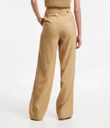 Pantalón de vestir color beige, de corte recto, con cintura alta, trabillas y cinturón cruzado. Presenta pliegues delanteros y bolsillos laterales.