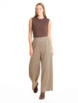 Pantalón de tiro alto con diseño wide leg y cintura elástica. Presenta un estampado de cuadros tipo gales en tonos marrones y negros, con bolsillos funcionales en la parte delantera.