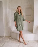 Vestido camisero corto de lino verde militar, con cuello camisero, botonadura frontal, bolsillos y mangas largas con presilla para arremangar.