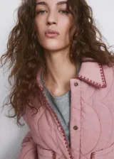Chaqueta oversize acolchada de color rosado con diseño pespuntado en zigzag, cuello camisero, manga larga, bolsillos delanteros de parche y ribetes en contraste.