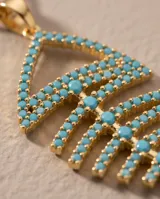 Collar de bronce en tono dorado con una fina cadena y un dije colgante en forma de espina de pescado, decorado con circonias de color turquesa.