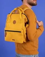 Mochila urbana Cabaia modelo Adventurer, color amarillo, con diseño de apertura amplia, asas superiores reforzadas, bolsillo frontal con cierre y parche de cuero sintético con logo de la marca.