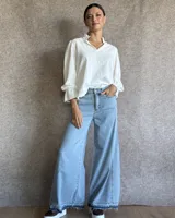 Jean de tiro medio con corte wide leg y diseño de botamanga con ruedo desflecado y detalle de doble tono en el bajo.