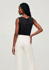 Musculosa de color negro, sin mangas, con elegante cuello drapeado y diseño ajustado.