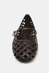 Zapato plano tipo bailarina color marrón oscuro, con capellada trenzada, tira delantera con hebilla metálica y punta redonda.