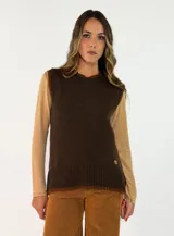 Chaleco de punto en color crema con detalles de ribetes en color marrón oscuro en el cuello, sisas y ruedo. Presenta un diseño clásico con cuello redondo y un pequeño aplique decorativo en el lateral inferior.