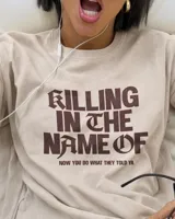 Remera oversize color beige con efecto acid wash y estampa frontal en marrón con la frase "Killing In The Name Of".