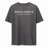 Remera de algodón con efecto lavado, de corte oversize y manga corta. Presenta un estampado tipográfico en la espalda con la frase 'RESILIENCE FORGED TO PREVAIL'.