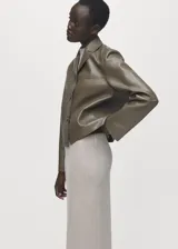 Chaqueta Sabi de cuero sintético en color verde militar, con cuello camisero, cierre frontal con botones y bolsillos de parche delanteros.