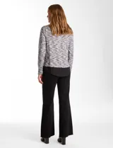 Buzo de tejido fino con efecto melange en tonos tierra, que incorpora cuello y ruedo inferior en tela tipo gasa negra, simulando una camisa debajo. Posee mangas largas y un diseño de corte recto.