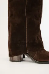 Bota de caña alta de gamuza color marrón, con diseño volcado y taco cuadrado.