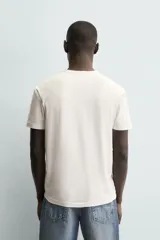 Camiseta blanca de manga corta con cuello redondo y tapeta de botones frontal (cuello panadero o henley).