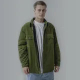 Campera color borgoña de pana con cuello camisero, cierre frontal con botones a presión y dos bolsillos de parche en el pecho. Interior acolchado con patrón de rombos.