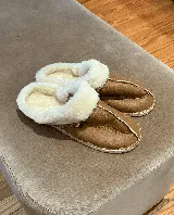 Pantuflas marrones confeccionadas en cuero lanar con suela de goma.