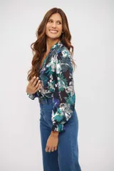 Camisa de manga larga con estampado floral en tonos azul, turquesa y blanco. Presenta cuello en V, cierre frontal con botones y puños elásticos con volados.