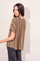 Blusa color beige con estampado animal print en marrón, de corte holgado y mangas cortas.