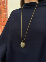 Collar de cadena tipo veneciana en color dorado con dije de cabeza de pantera. El dije presenta un acabado dorado con incrustaciones de piedras negras y ojos en color verde.
