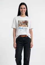 Remera blanca de manga corta con cuello redondo y estampado frontal tipo cuadro con texto decorativo en azul.