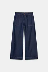 Jeans de tiro medio con corte wide leg y pernera ancha. Presenta bolsillos de plastrón en el delantero y cierre frontal con cremallera y botón.