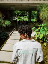 Camisa de lino con diseño de cuadrillé en tonos blanco y beige, de manga larga y cuello clásico. Presenta una pequeña estampa en el pecho y una estampa en la espalda, con un calce holgado y relajado.