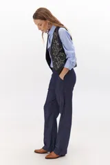 Chaleco marrón de simil cuero con bordado en color crema, cuello en V y cierre frontal con botones.