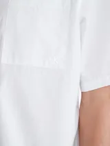 Camisa blanca de manga corta con cierre frontal con botones y bolsillo de pecho.