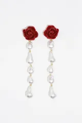Pendientes largos con diseño de rosa roja en la parte superior y una serie de perlas barrocas colgantes unidas por eslabones dorados.