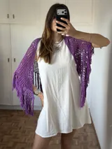 Chal tejido en crochet color violeta, con diseño de red y terminaciones de flecos en los bordes.