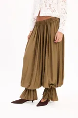 Pantalón negro de corte amplio, con cintura elástica fruncida y diseño abombacho con volados en los tobillos.