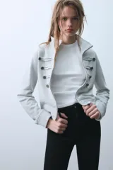 Sudadera de algodón gris con cuello subido, cierre frontal con cremallera y detalle de botones decorativos en el frente estilo militar.