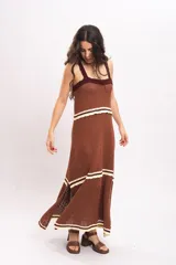 Vestido largo de tejido de punto color marrón, con tirantes anchos, escote cuadrado con detalles en tono bordó y franjas horizontales en color crema con terminación ondulada.