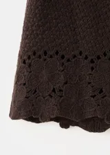 Short marrón de tiro medio, con diseño recto, cintura ajustable con elástico y detalles bordados calados con terminación ondulada en el ruedo.