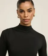 Blusa negra de mangas largas, con cuello alto y fruncidos delanteros.