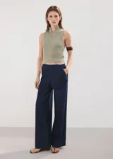 Jeans Avery de corte wide leg y tiro medio, con diseño largo, bolsillos laterales y traseros, y cierre oculto con botón, gancho y cremallera.