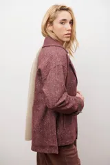 Chaquetón de lana color bordó con diseño de espiga y motas blancas. Tiene solapa, doble abotonadura frontal, mangas largas con detalle de correa y hebilla en los puños.