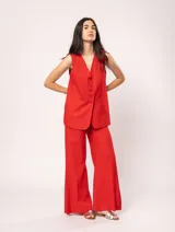 Chaleco color crema de lino con corte sastrero, largo a la cadera, forro interno, botones delanteros, silueta levemente entallada y tajo cruzado en la espalda.