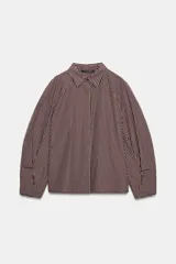 Camisa de manga larga con cuello solapa y diseño de cuadros pequeños. Presenta mangas con pliegues y cierre frontal con botones ocultos.