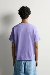 Camiseta regular fit de algodón con textura flamé, cuello redondo y manga corta, en color lila con efecto lavado y pequeña etiqueta estampada en el borde inferior.