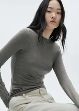 Camiseta de manga larga entallada con cuello redondo, confeccionada en tejido suave y elástico.