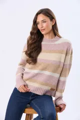 Buzo tejido de punto con diseño de rayas horizontales en tonos rosado, beige y crema. Presenta cuello redondo, mangas largas y puños acanalados, con un pequeño aplique de cuero sintético en el ruedo.