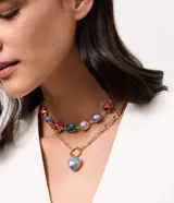 Collar de bijouterie en metal dorado con diseño de dos capas, decorado con chatones coloridos de resina en tonos rosa, verde y celeste, y dije frontal en forma de corazón.
