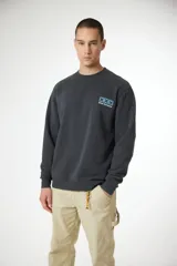 Buzo de cuello redondo color gris oscuro con efecto lavado, manga larga y puños y ruedo acanalados. Presenta un pequeño estampado en el pecho con tres cruces azules y el texto "blue banana".