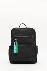 Mochila urbana de nylon color negro, con múltiples bolsillos exteriores con cierre, asas acolchadas regulables y asa superior. Incluye un detalle colgante decorativo en tonos celeste y verde.