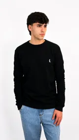 Buzo de punto negro con cuello redondo, mangas largas y puños acanalados. Presenta un pequeño logo bordado en color blanco en el pecho.