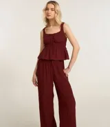 Pantalón recto de viscosa color bordó, con superficie texturizada y lazo ajustable en la cintura.