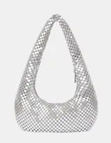 Bolso de mano tipo hobo plateado, confeccionado con malla metálica de lentejuelas redondas. Presenta un asa única y curva para llevar al hombro y un cierre de cremallera lateral.